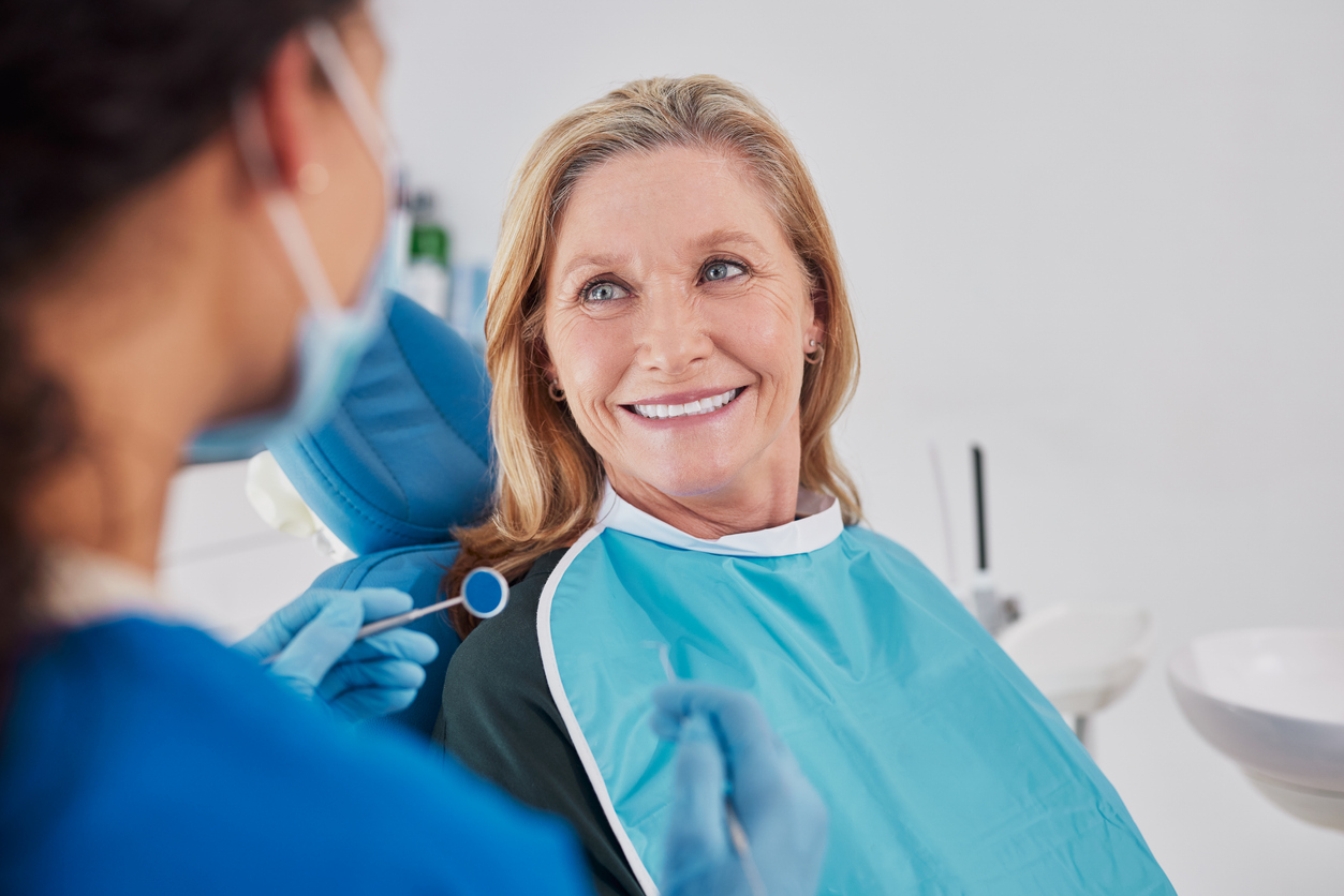 Smiling patient enjoying a meal with permanent teeth after All-on-4 dental implants